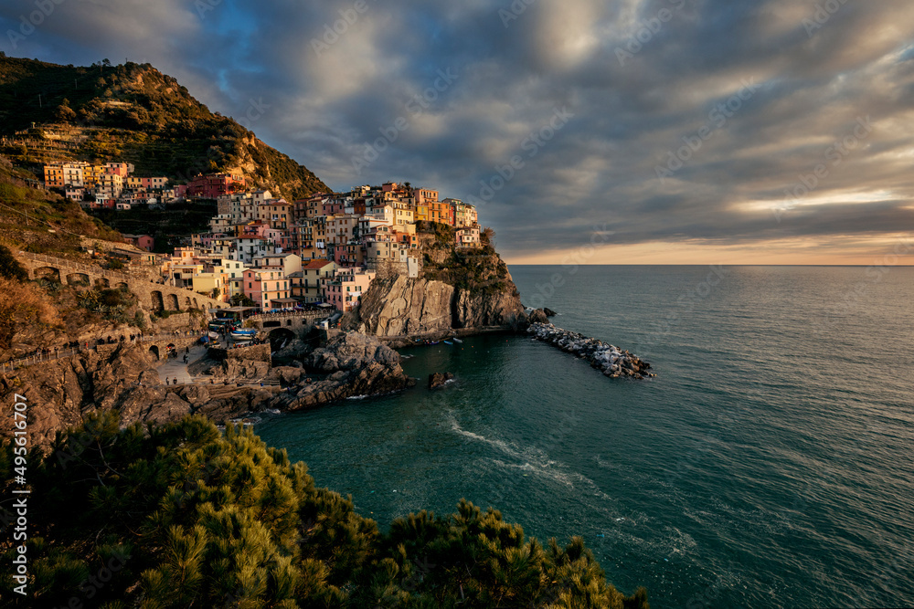 view of the town of manarola by the sea in italy at sunset