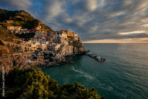 view of the town of manarola by the sea in italy at sunset