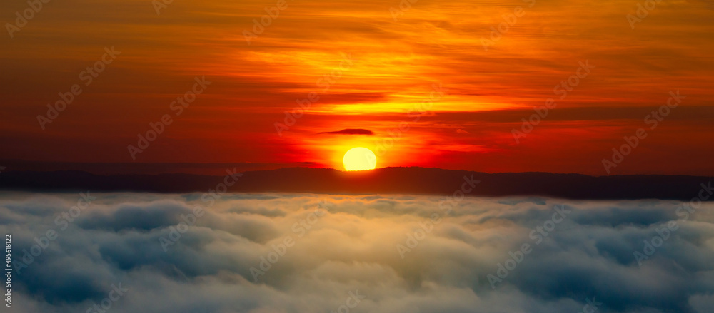 Panorama fog with vivid orange sunrise  sky clouds background.Big Sun Over fog in the morning.