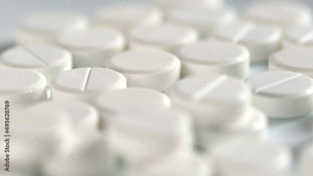 The medicine concept. white medical pills rotating closeup. Pills and drugs. Pharmaceutical Industry. drugs on the production line. moving background. close-up. view from above.super slow motion The medicine concept. white medical pills rotating closeup. Pills and drugs. Pharmaceutical Industry. drugs on the production line. moving background. close-up. view from above.super slow motion