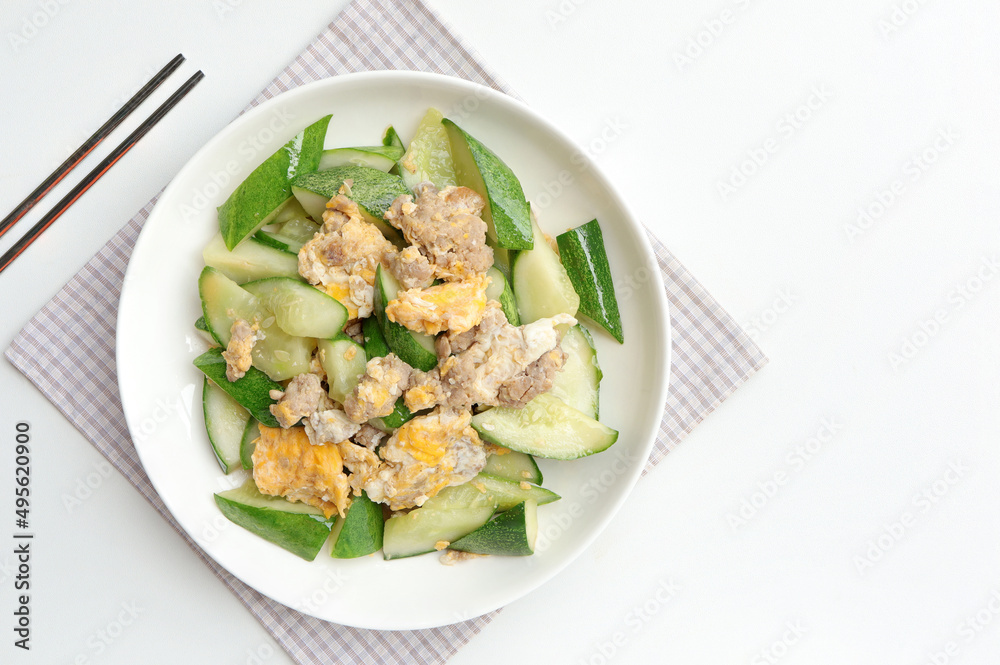 Asian stir-fried cucumber with minced pork, egg and oyster sauce in white plate. Asian food style. Asian stir-fried cucumber with minced pork, egg and oyster sauce in white plate. Asian food style.