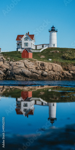 Vertical shot of the Nubble Lighthouse and its reflection in the lake in Maine, USA