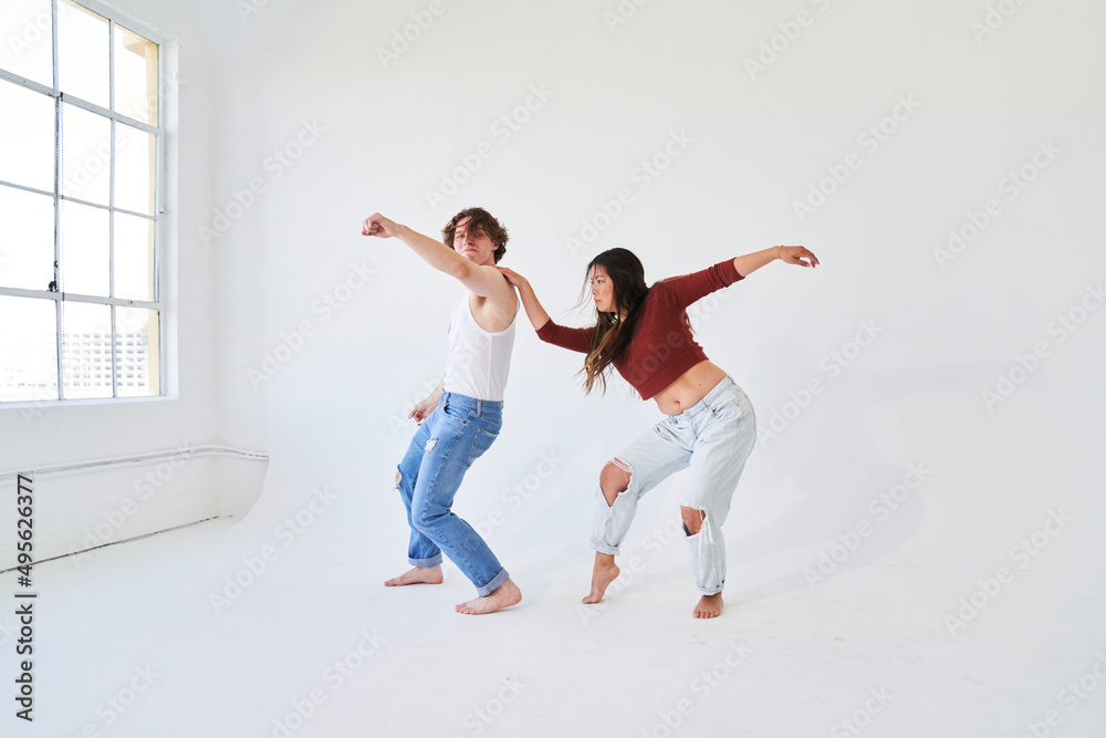 couple dancing in white room with window