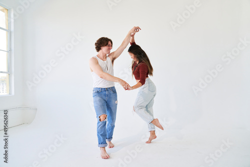 couple dancing with hands held in white room