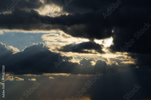 beautiful dramatic sky, bright sunlight and dark silhouette of clouds as background