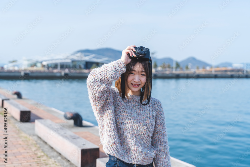 海辺にいる若いカメラ女子