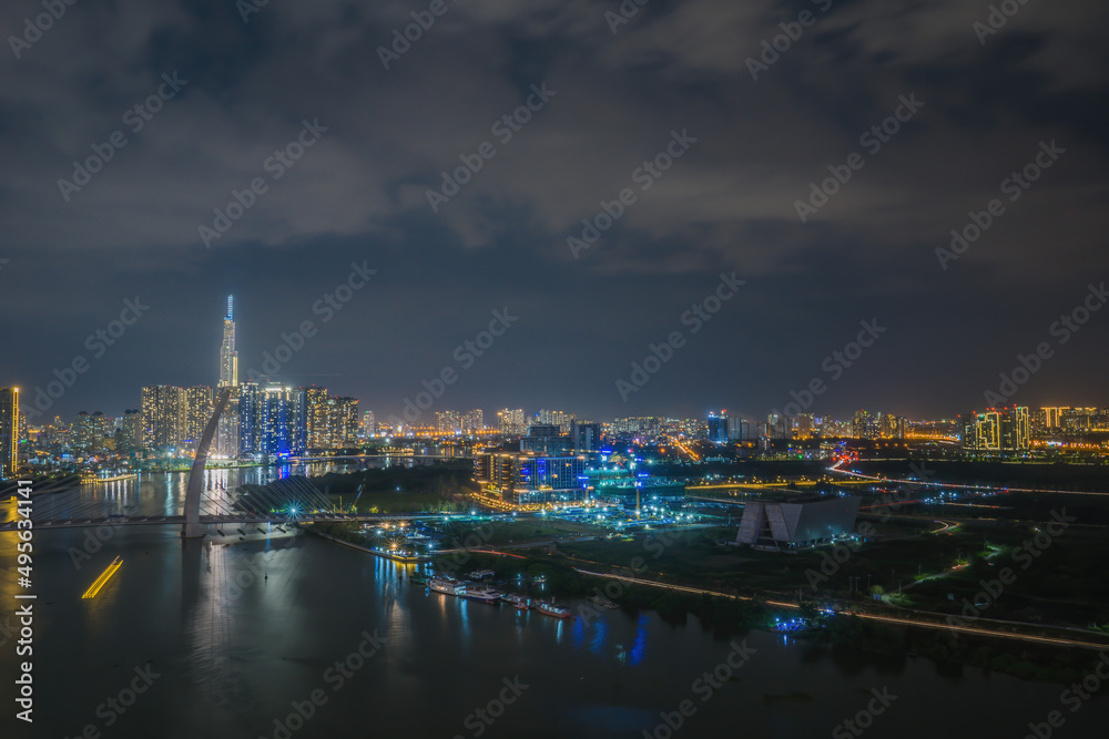 Aerial view of Bitexco Tower, buildings, roads, Thu Thiem 2 bridge and Saigon river in Ho Chi Minh city - Far away is Landmark 81 skyscrapper. This city is a popular tourist destination of Vietnam