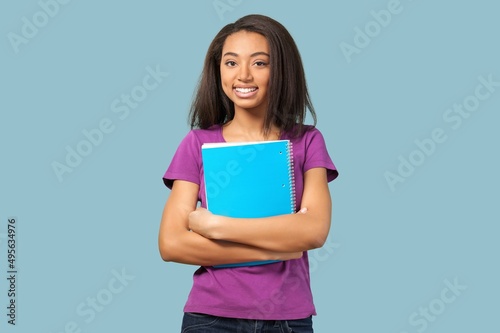Young girl teen student in denim clothes with backpack and holds books. Education concept.
