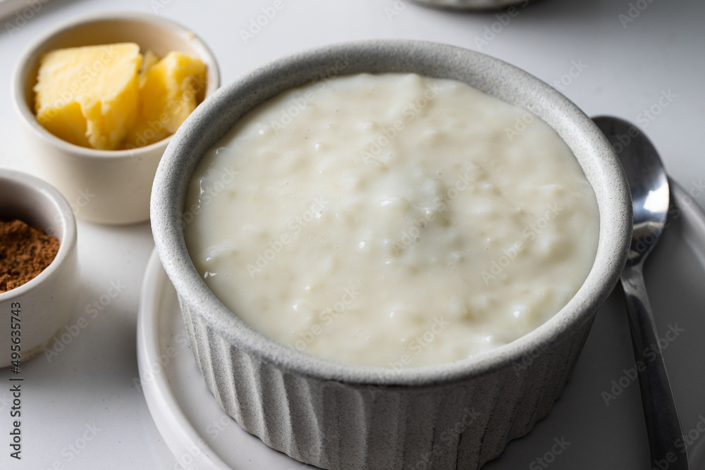 Rice pudding in grey ceramic bowl on white table. Breakfast Rice pudding in grey ceramic bowl on white table. Breakfast