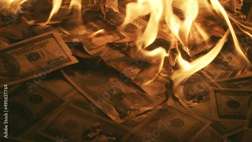 Bunch of dollar bills slowly burn up in closeup Macro. Concept of a big waste of money