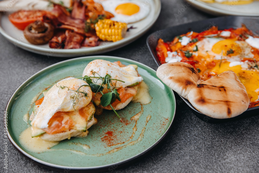 Different egg dishes. Poached eggs with salmon and avocado on a plate. Different egg dishes. Poached eggs with salmon and avocado on a plate.