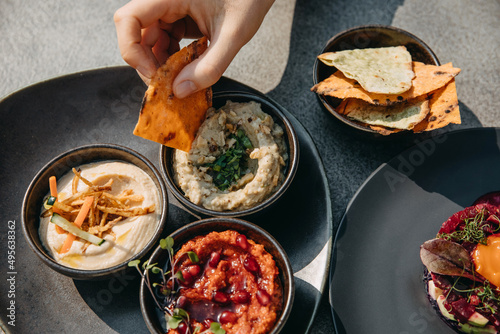 Slika na platnu Various aperitif humus dishes with grilled pita