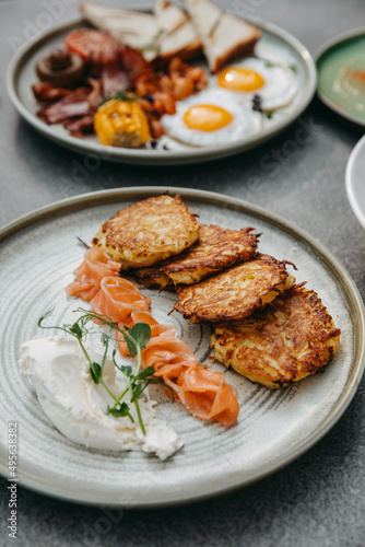 Grated potato pancakes with cottage cheese and salmon on a plate.