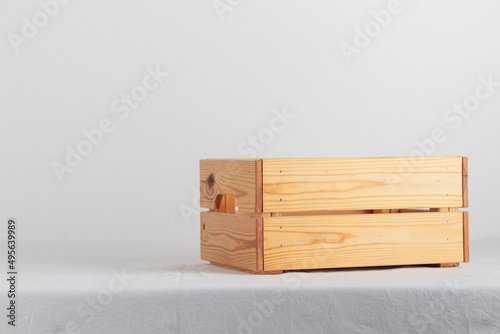 Empty wooden box on a table near white wall