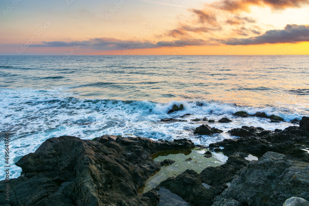 calm morning at the sea. nature scenery with rocky coast at dawn. clouds glowing on the sky. scenic picture-postcard view. black sea, bulgaria, europe