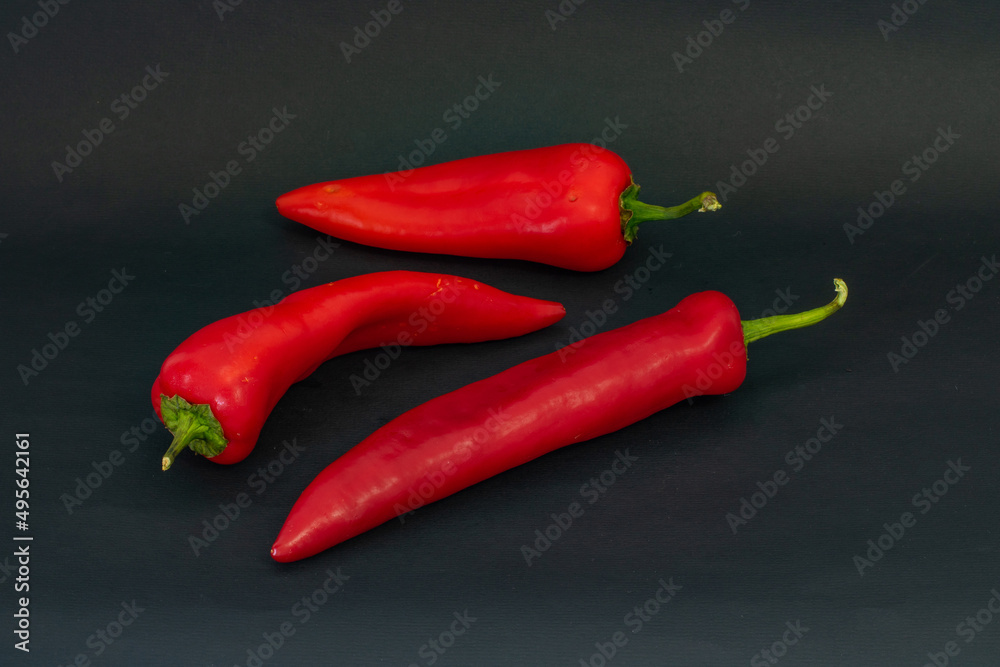 Red peppers on a black background, three red peppers on a black background