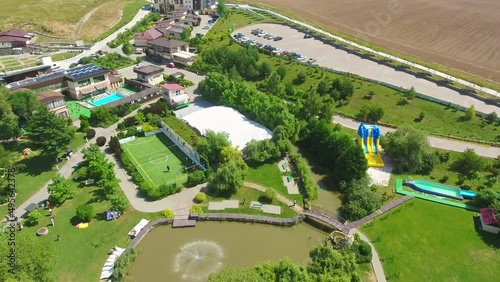 Recreational zone with private bungalows, swimming pools, tennis court and children playgrounds. People walking and resting in rural area. Top view. photo