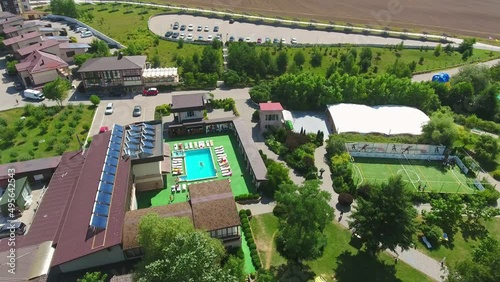 Green, clean and well-structured territory of spa-resort outside the city. Luxury outdoor swimming pool and relaxing zone around it. Birdseye view. photo