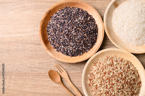 Various Organic Thai rice grain (brown, purple and white rice) on wooden background, Table top view