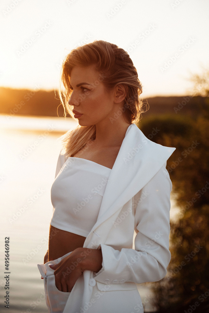 Stunning woman in stylish suit enjoying summer sunset