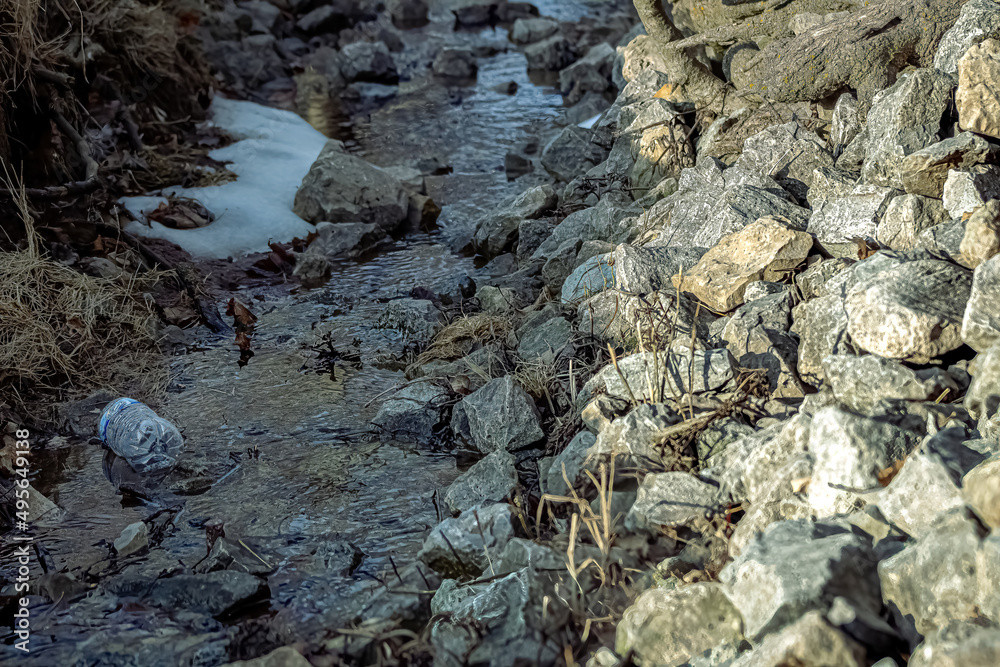 Obraz premium Water bottle floating down spring stream