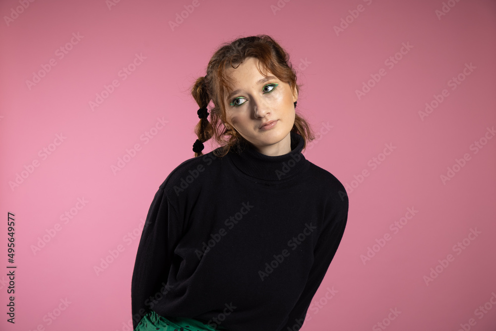 Friendly young woman with a vivacious smile and emotion . Young red-haired girl on pink background.