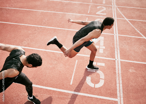 Fototapeta Naklejka Na Ścianę i Meble -  Hes stolen it. High angle shot of two handsome young male athletes crossing the finishing line during their race on a track.