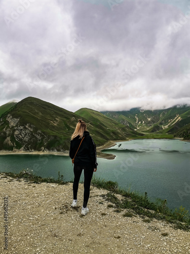 A girl on the background of Lake Kezenoy-am in the Caucasus mountains in Chechnya, Russia June 2021.