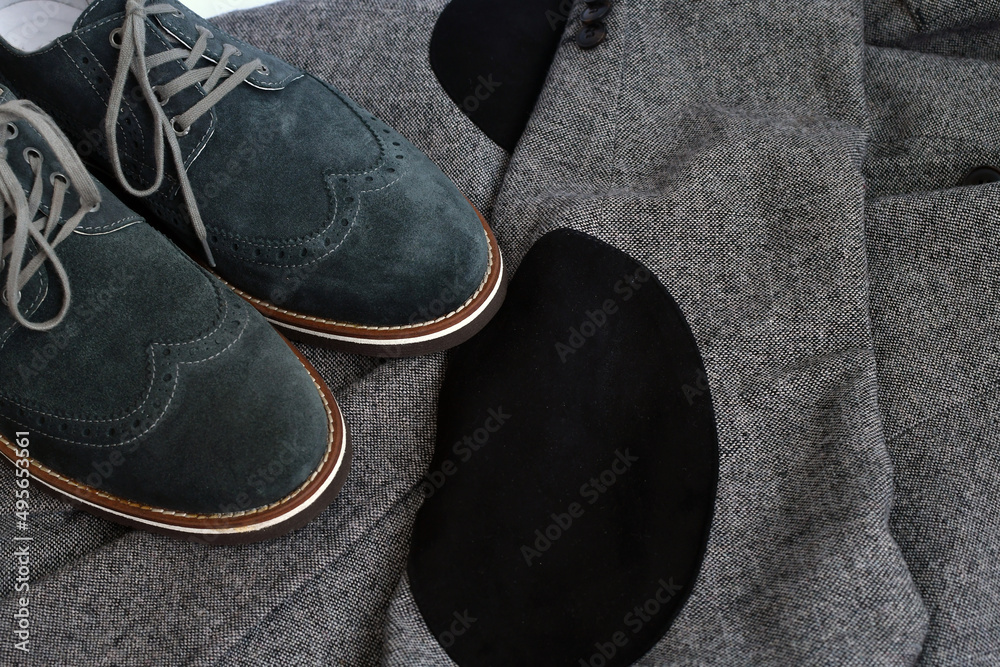 Dark green suede derby shoes on grey tweed fabric background. Selective focus. Dark green suede derby shoes on grey tweed fabric background. Selective focus.