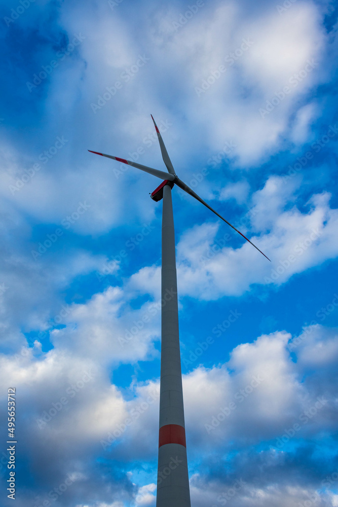 Single wind turbine with cloudy sky in Germany, low angle view. Green energy source. Single wind turbine with cloudy sky in Germany, low angle view. Green energy source.