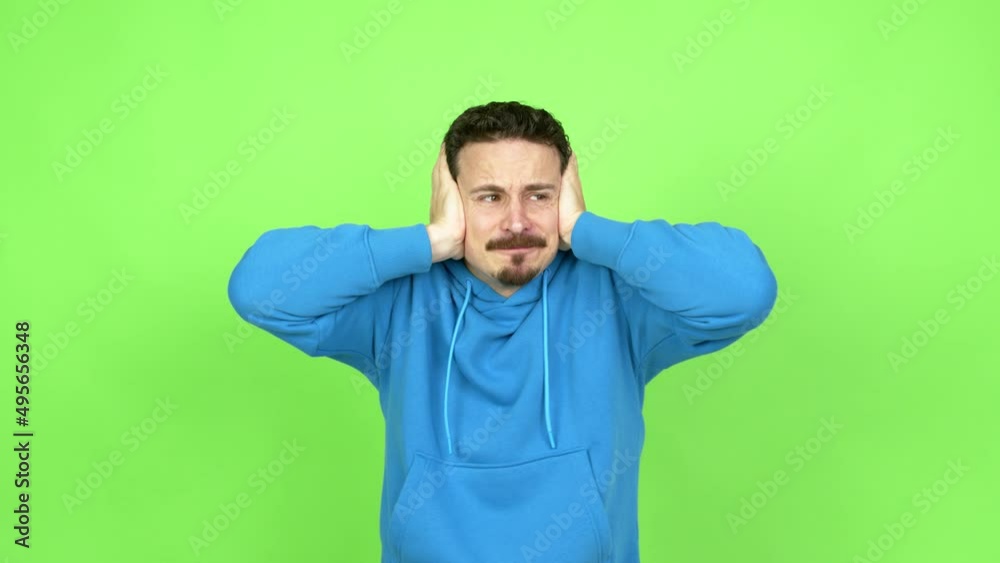Man covering both ears with hands. Frustrated expression over isolated background. Green screen chroma key Man covering both ears with hands. Frustrated expression over isolated background. Green screen chroma key
