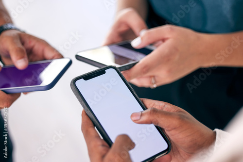 Its all about the connection. Shot of a group of business people using their smartphones together.