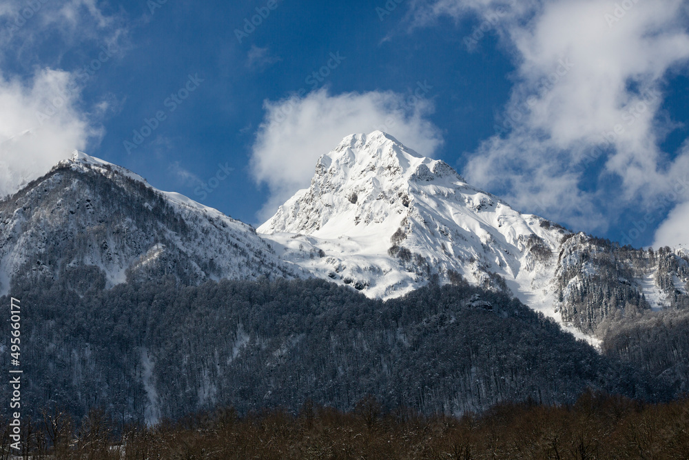Mountain peaks covered with snow and blue sky. The concept of winter holidays Mountain peaks covered with snow and blue sky. The concept of winter holidays