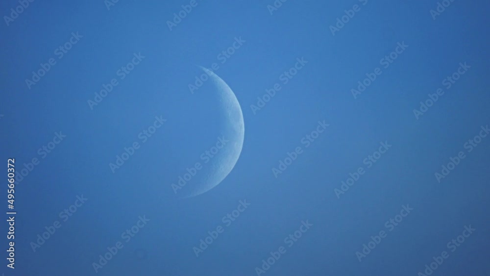the incomplete moon moves across the blue sky through the clouds. Time Lapse the incomplete moon moves across the blue sky through the clouds. Time Lapse