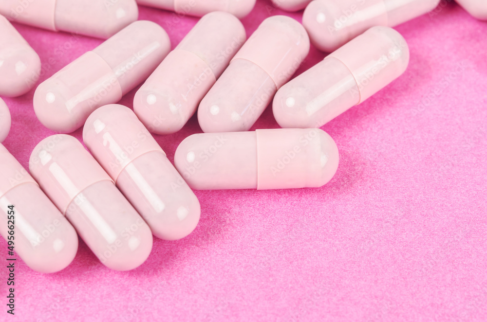 Pink capsule pills on pink background Pink capsule pills on pink background