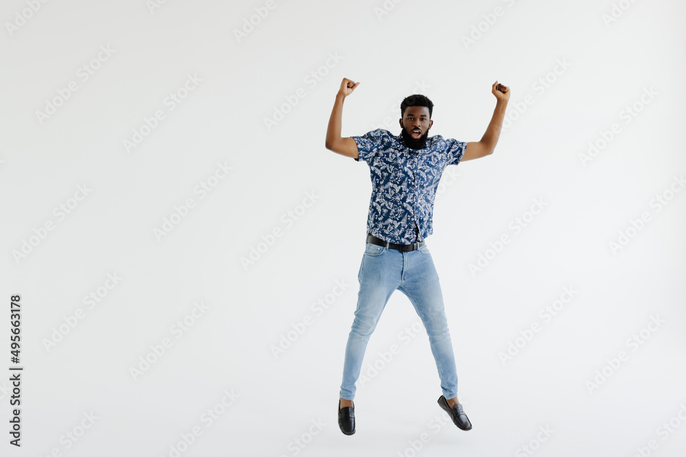 Portrait of a cheerful afro american man in headphones jumping isolated on a white background Portrait of a cheerful afro american man in headphones jumping isolated on a white background