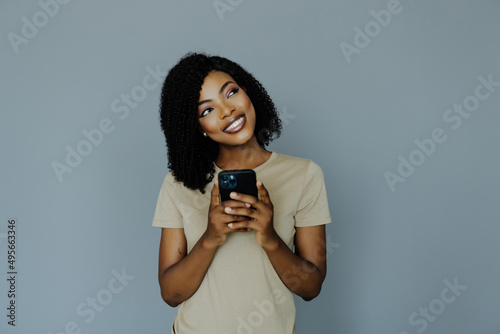 Portrait African woman using phone isolated on grey background