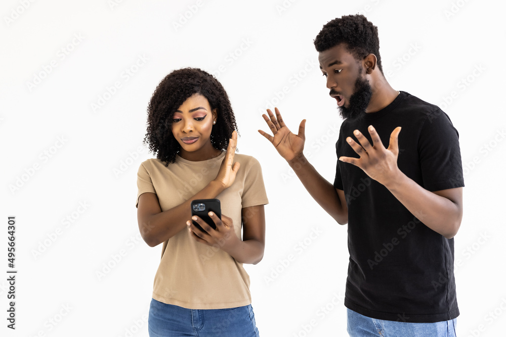 Portrait of a afro american couple querrel with mobile phone isolated over white background Portrait of a afro american couple querrel with mobile phone isolated over white background