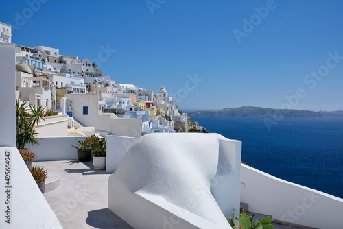 Breathtaking view of a rooftop, the picturesque village of Fira and the aegean sea on a sunny day in Santorini