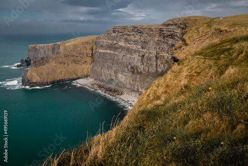 The Cliffs of Moher in Ireland's County Clare on a clear, sunny day at sunset. Burren, UNESCO Geopark, tall cliffs, Europe, Wild Atlantic Way, Atlantic Ocean, Doolin, Liscannor, grass, rock.