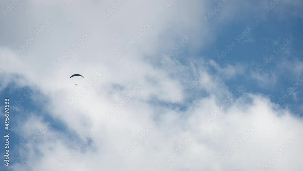 Paragliding sky-diver flying high between the clouds. Extreme sports activities concept. Slow motion. Paragliding sky-diver flying high between the clouds. Extreme sports activities concept. Slow motion.