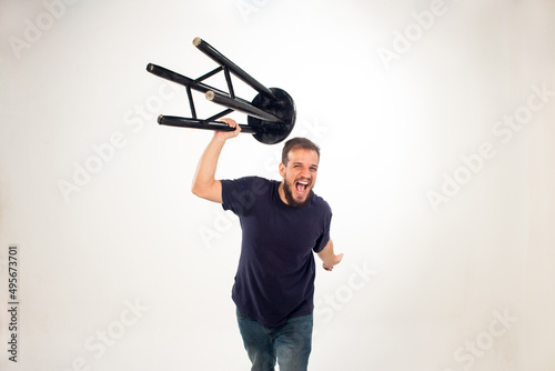 Caucasian male get nervous and throwing a chair on the white background photo