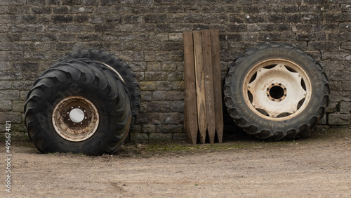 Tractor tyres and stakes leaning against barn wall