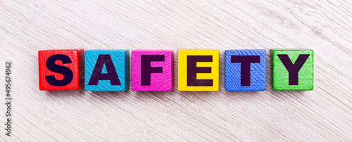 On a light wooden background, multi-colored wooden cubes with the text SAFETY