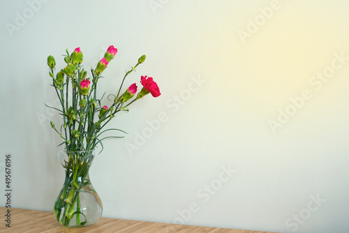 Bouquet of pink flowers in a vase on a light background. Carnations.