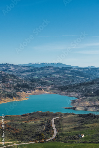 Panoramic view of the road along the Zahara de la Sierra reservoir with the mountains in the background.