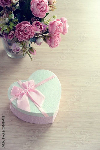 heart gift box with rose flowers bouquet on table  abstract blurred background. spring summer season  festive composition. romantic gift for women. top view. copy space