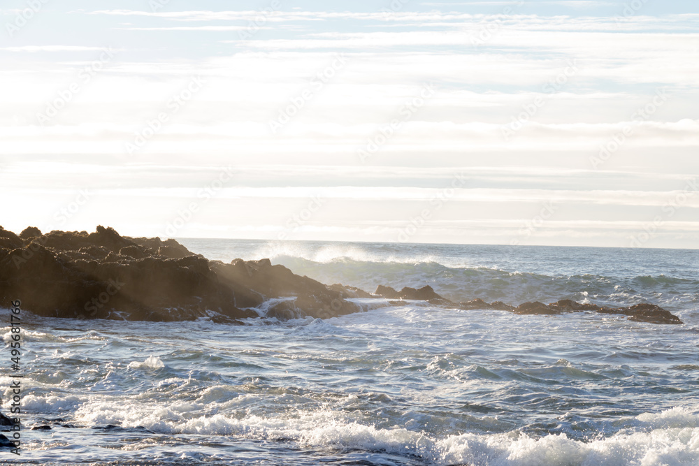 Fototapeta premium waves hitting rocks on the shore and beach