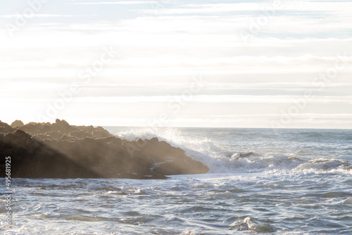 waves hitting rocks on the shore and beach