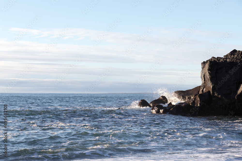 waves hitting rocks on the shore and beach